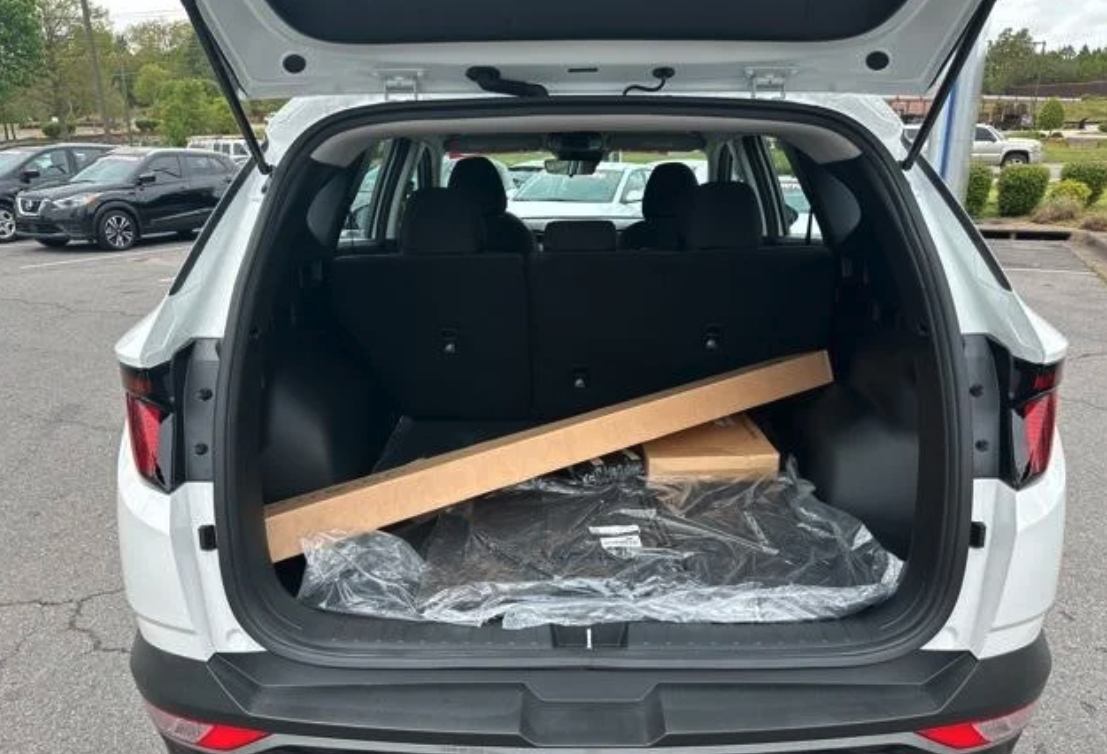 Open trunk of a Hyundai SUV with boxed accessories inside